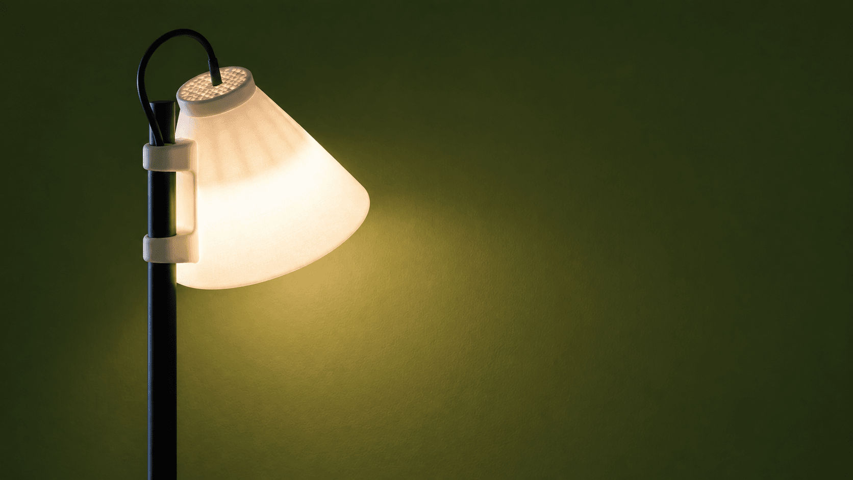 A softly glowing lamp against an olive wall